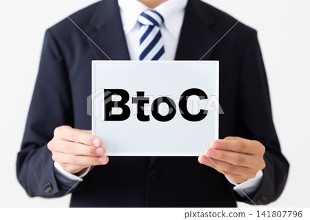 A young businessman in a business suit holding a B2C whiteboard. A young businessman in a business suit holding a B2C whiteboard. 141807796