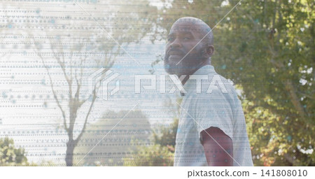 Standing man turning head upward in park among trees, wearing pale shirt, with patterned overlay Standing man turning head upward in park among trees, wearing pale shirt, with patterned overlay 141808010