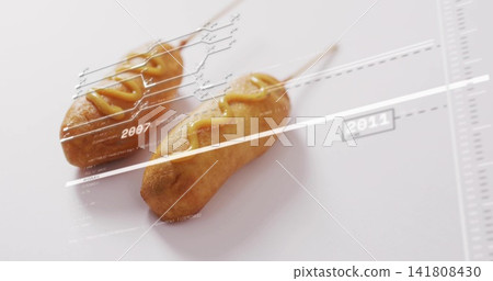 Showing pair of corn dogs on wooden sticks angled on table, featuring mustard and labels 2007-2011 Showing pair of corn dogs on wooden sticks angled on table, featuring mustard and labels 2007-2011 141808430
