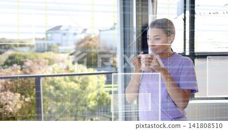 Standing woman in lilac tee holding white mug looking out glass door, digital overlay, copy space Standing woman in lilac tee holding white mug looking out glass door, digital overlay, copy space 141808510