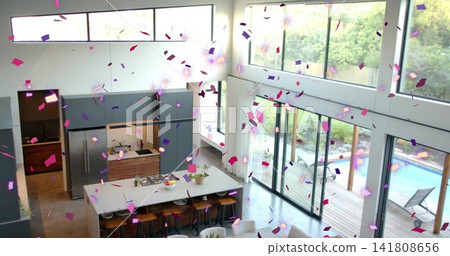 Falling confetti filling air above white countertop kitchen island with gas cooktop in modern home Falling confetti filling air above white countertop kitchen island with gas cooktop in modern home 141808656