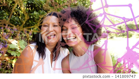 Smiling mother and daughter leaning to camera in garden, in sleeveless tops and network overlay Smiling mother and daughter leaning to camera in garden, in sleeveless tops and network overlay 141809747