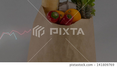 Sitting brown paper bag holding red peppers, orange, baguette, egg carton, greens on gray tabletop Sitting brown paper bag holding red peppers, orange, baguette, egg carton, greens on gray tabletop 141809769