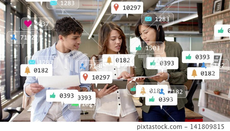 Reviewing team in business attire examining tablet and holding papers in open office with alerts Reviewing team in business attire examining tablet and holding papers in open office with alerts 141809815