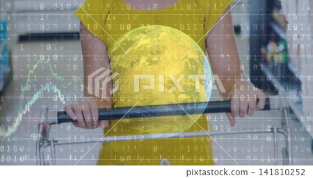 Standing shopper in yellow dress holding metal cart handle in supermarket aisle, with globe overlay Standing shopper in yellow dress holding metal cart handle in supermarket aisle, with globe overlay 141810252