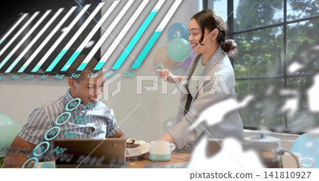 Two adults exchanging dessert at wood table, man striped shirt, woman cardigan, laptop, AR overlays Two adults exchanging dessert at wood table, man striped shirt, woman cardigan, laptop, AR overlays 141810927