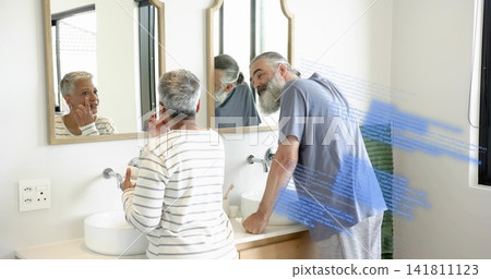 Touching cheek, striped-top woman and blue-T-shirt man leaning at bathroom double vanity, overlay 141811123