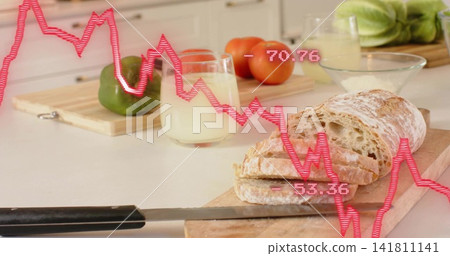 Slicing rustic loaf on wood board in home kitchen, with serrated black-handled knife and pink graph Slicing rustic loaf on wood board in home kitchen, with serrated black-handled knife and pink graph 141811141