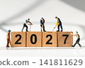 Miniature Construction Workers Building Wooden 2027 Blocks for New Year Business Success Concept 141811629