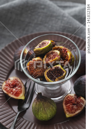 Fresh figs served in a glass dish, and a tranquil dining table (viewed from directly above). Fresh figs served in a glass dish, and a tranquil dining table (viewed from directly above). 141812384