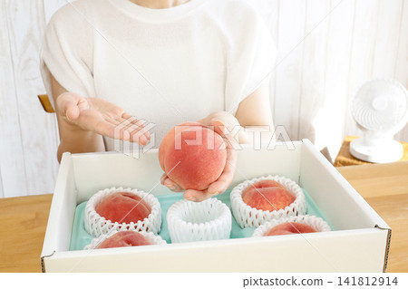 Summer fruit gift: A woman's hand holding a peach. Summer fruit gift: A woman's hand holding a peach. 141812914