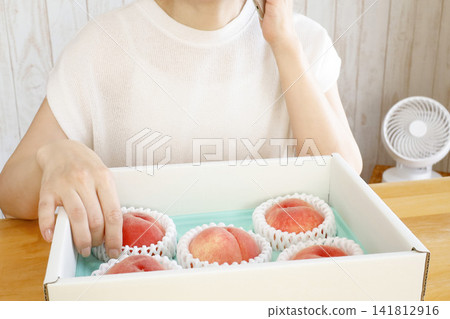 A woman calls to thank them for the peaches she received as a summer fruit gift. A woman calls to thank them for the peaches she received as a summer fruit gift. 141812916