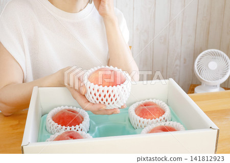 A woman calls to thank them for the peaches she received as a summer fruit gift. A woman calls to thank them for the peaches she received as a summer fruit gift. 141812923