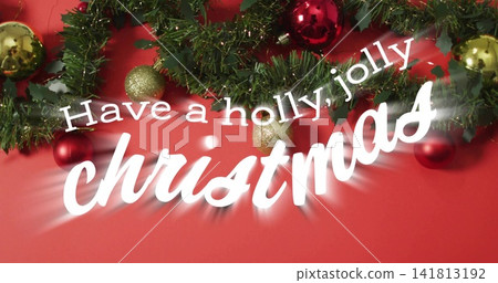 Displaying white greeting text with garland and holly on red backdrop, featuring red gold baubles Displaying white greeting text with garland and holly on red backdrop, featuring red gold baubles 141813192