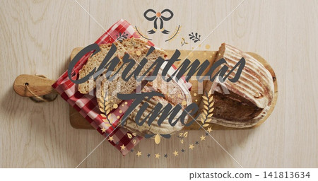 Showing two sourdough loaves, one partially sliced on paddleboard at home Christmas Time overlay Showing two sourdough loaves, one partially sliced on paddleboard at home Christmas Time overlay 141813634
