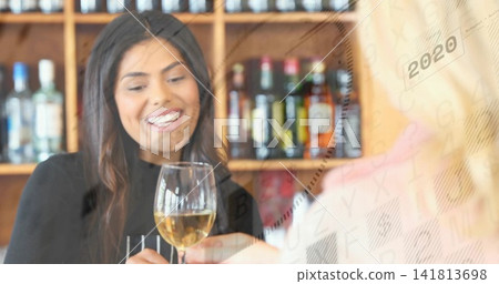 Smiling woman holding stemmed wine glass at wine bar, dark top, bottle shelves, 2020 keypad Smiling woman holding stemmed wine glass at wine bar, dark top, bottle shelves, 2020 keypad 141813698