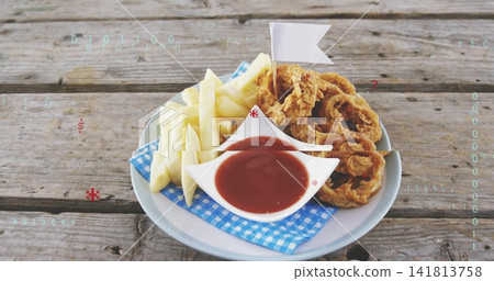 Showing plate holding onion rings and fries with boat-sauce on picnic-table, digital-overlay Showing plate holding onion rings and fries with boat-sauce on picnic-table, digital-overlay 141813758
