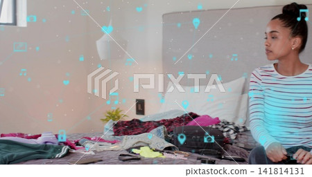 Sitting woman in striped top and dark pants packing suitcase in bedroom, AR icons, copy space Sitting woman in striped top and dark pants packing suitcase in bedroom, AR icons, copy space 141814131