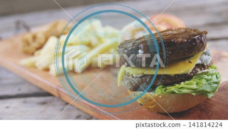 Featuring double-patty cheeseburger sitting on wooden board with fries and blue overlay, copy space Featuring double-patty cheeseburger sitting on wooden board with fries and blue overlay, copy space 141814224