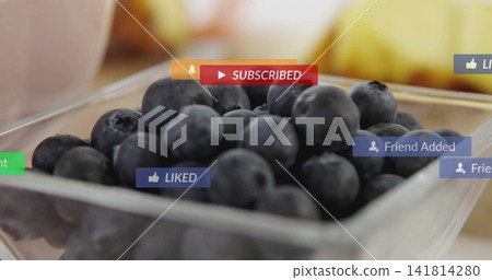 Displaying glass bowl filled with blueberries on kitchen table, showing SUBSCRIBED, LIKED icons Displaying glass bowl filled with blueberries on kitchen table, showing SUBSCRIBED, LIKED icons 141814280