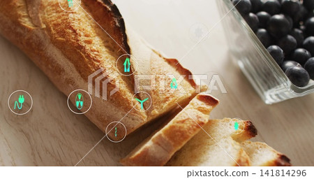 Displaying sliced crusty baguette resting on light wood with blueberry bowl and green UI icons Displaying sliced crusty baguette resting on light wood with blueberry bowl and green UI icons 141814296