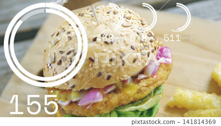 Featuring seeded bun sandwich with breaded patty, lettuce, toothpick, sauce on wooden board, UI 141814369