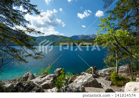 Travel landscape of Eibsee lake and mountain peak in Alps in Bavaria, Germany, scenic summer nature panorama with forest und mountains. Alpine landscape Travel landscape of Eibsee lake and mountain peak in Alps in Bavaria, Germany, scenic summer nature panorama with forest und mountains. Alpine landscape 141814574