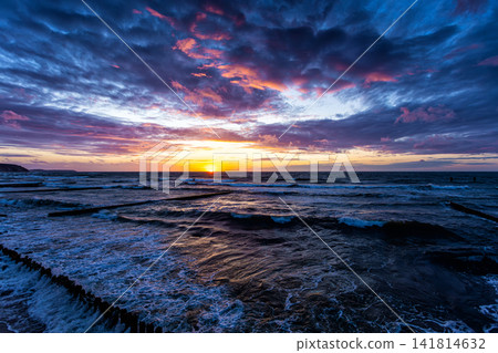 Scenic sundown on the sea shore with a breakwaters Scenic sundown on the sea shore with a breakwaters 141814632