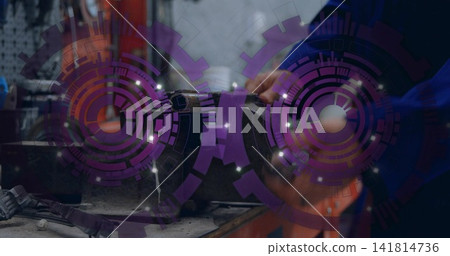 Adjusting mechanic in blue coverall tightening metal cylinder in bench vise at workshop, purple HUD Adjusting mechanic in blue coverall tightening metal cylinder in bench vise at workshop, purple HUD 141814736