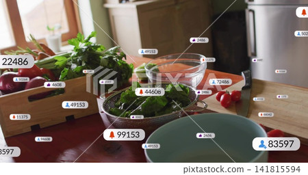 Sitting steel colander holding leafy greens on table by window with knife, tomatoes, badges Sitting steel colander holding leafy greens on table by window with knife, tomatoes, badges 141815594
