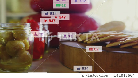 Showing cracker stack resting on round board at kitchen window, with olive jar, jam, apples, badges Showing cracker stack resting on round board at kitchen window, with olive jar, jam, apples, badges 141815664