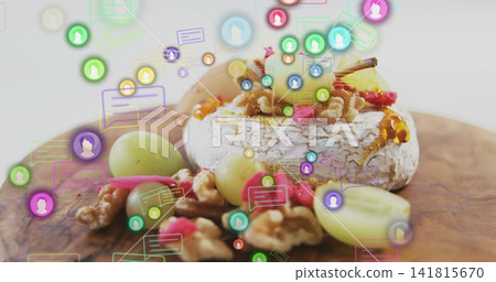 Showing ripened cheese wheel topped with honey and walnuts on cutting board, floating digital icons Showing ripened cheese wheel topped with honey and walnuts on cutting board, floating digital icons 141815670