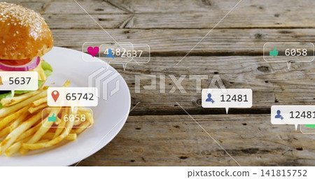 Showing ceramic plate holding burger, fries on wooden table, with notification bubbles, copy space Showing ceramic plate holding burger, fries on wooden table, with notification bubbles, copy space 141815752