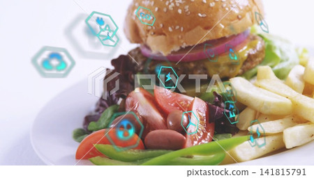 Displaying plated sesame bun burger with melted cheese, fries, salad on white plate, teal hex icons Displaying plated sesame bun burger with melted cheese, fries, salad on white plate, teal hex icons 141815791