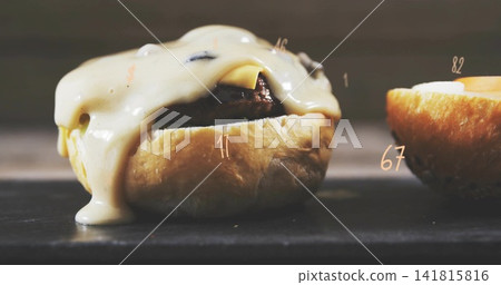 Showing cheeseburger with melted cheese dripping from seared patty on dark slate, numeric overlays Showing cheeseburger with melted cheese dripping from seared patty on dark slate, numeric overlays 141815816