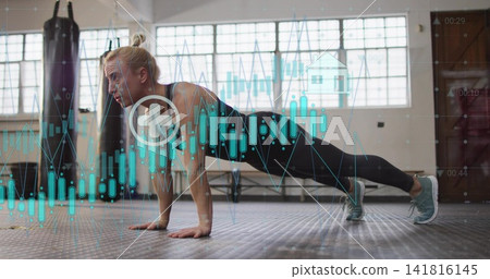 Planking mid-adult woman on gym floor, wearing black activewear, with punching bag and teal graphs Planking mid-adult woman on gym floor, wearing black activewear, with punching bag and teal graphs 141816145