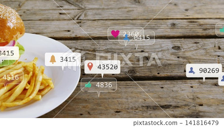 Showing white plate with sesame bun, fries sitting on worn tabletop notification icons, copy space 141816479