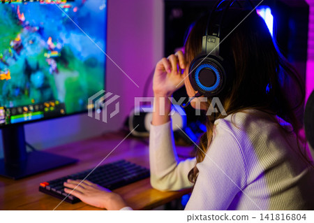 Game Over. Asian gamer playing online video game she losing and sad on computer PC colorful neon LED lights, young woman in gaming headphones feeling disappointed about lost game 141816804
