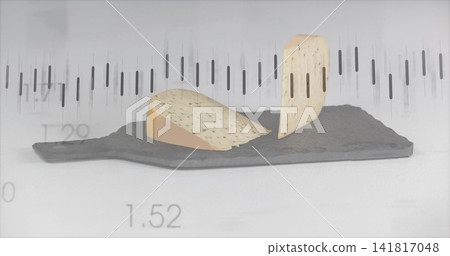 Displaying two herbed cheese wedges, one resting one standing on dark slate with faint numeric bars Displaying two herbed cheese wedges, one resting one standing on dark slate with faint numeric bars 141817048