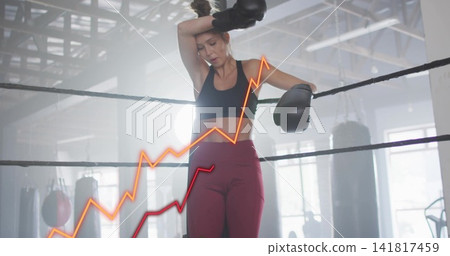 Leaning boxer holding gloved hand to brow in warehouse ring, wearing bra leggings orange red graphs Leaning boxer holding gloved hand to brow in warehouse ring, wearing bra leggings orange red graphs 141817459