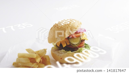 Showing sesame-bun burger layering lettuce patty cheese pickles on studio with fries and glyphs Showing sesame-bun burger layering lettuce patty cheese pickles on studio with fries and glyphs 141817647