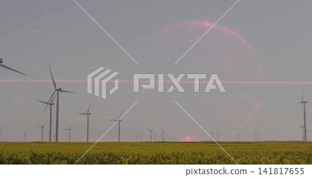 Lining tall wind turbines rotating across rural plain, highlighting yellow field and pink halo Lining tall wind turbines rotating across rural plain, highlighting yellow field and pink halo 141817655