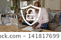 Reviewing papers senior man wearing pink shirt and jeans at home with laptop, dog, security shield 141817699