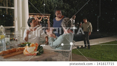 Chatting three women leaning at deck table, woman in dark blue dress, with floral centerpiece Chatting three women leaning at deck table, woman in dark blue dress, with floral centerpiece 141817715