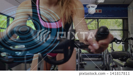 Leaning cyclist wearing black tank pink-trim shorts gripping spin bike holding knob in gym HUD over Leaning cyclist wearing black tank pink-trim shorts gripping spin bike holding knob in gym HUD over 141817811