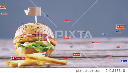 Showcasing sesame-seed burger with flag skewer and fries on wooden tabletop, with floating icons Showcasing sesame-seed burger with flag skewer and fries on wooden tabletop, with floating icons 141817848