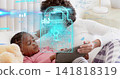 Reclining mom and daughter using tablet in bedroom, wearing white and pink tops, showing padlock 141818319