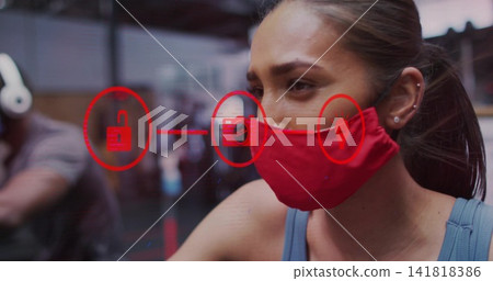 Pedaling woman wearing red cloth mask, blue tank top, on stationary bike at gym, overlay icons Pedaling woman wearing red cloth mask, blue tank top, on stationary bike at gym, overlay icons 141818386