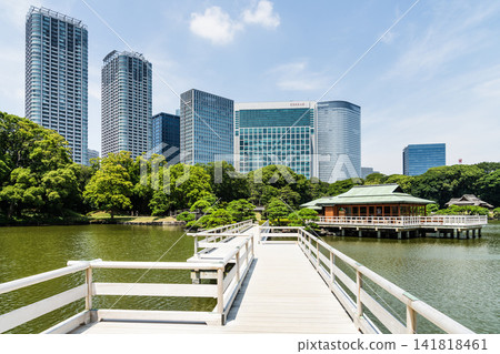Across Otsutaibashi Bridge to the Shioiri-no-ike (Tidal Pond) is Nakajima no Ochaya in the Hama-rikyu Garden in Chuo City, Tokyo, Japan, with the skyscrapers of Shiodome. Across Otsutaibashi Bridge to the Shioiri-no-ike (Tidal Pond) is Nakajima no Ochaya in the Hama-rikyu Garden in Chuo City, Tokyo, Japan, with the skyscrapers of Shiodome. 141818461
