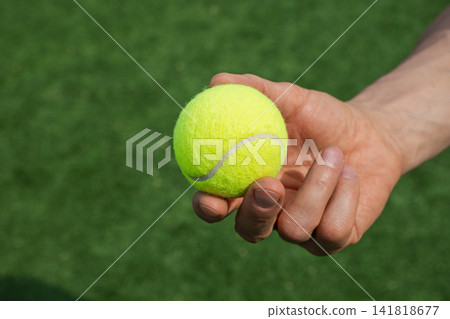 Close up of tennis ball in player hand Close up of tennis ball in player hand 141818677